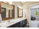 Elegant bathroom with double sinks, dark wood cabinets, and large mirrors for a luxurious feel at 120 Mearleaf Pl, Holly Springs, NC 27540