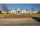 Beautiful white clubhouse exterior with manicured landscaping and a circular driveway at 120 Mearleaf Pl, Holly Springs, NC 27540