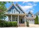 Charming two-story home featuring a welcoming front porch and a well-manicured lawn at 120 Mearleaf Pl, Holly Springs, NC 27540
