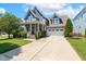 Beautiful two-story home with a spacious driveway and an attached garage, surrounded by green lawns and landscaping at 120 Mearleaf Pl, Holly Springs, NC 27540
