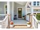 Inviting front porch with brick accents, potted plants, and a charming wooden front door at 120 Mearleaf Pl, Holly Springs, NC 27540