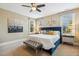 Bright main bedroom with plush blue bed, decorative pillows, bench, and natural light streaming through windows at 120 Mearleaf Pl, Holly Springs, NC 27540