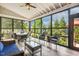 Bright sunroom with large windows, comfortable seating, and wood-look flooring at 120 Mearleaf Pl, Holly Springs, NC 27540