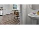 Stylish powder room featuring a modern pedestal sink and view to the open-concept living room at 121 N Chubb Rdg, Wilson's Mills, NC 27520