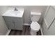 Bathroom featuring a white vanity and toilet, complemented by modern gray walls and flooring at 1222 Teakwood Pl, Raleigh, NC 27606