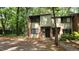 Charming two-story townhome with a brick facade and inviting front entrance nestled in a wooded setting at 1222 Teakwood Pl, Raleigh, NC 27606