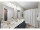 Updated bathroom with double sinks, white countertops, and modern lighting fixtures at 13017 Townfield Dr, Raleigh, NC 27614