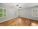 Bright and airy bedroom with hardwood floors and white shutters on the windows at 13017 Townfield Dr, Raleigh, NC 27614
