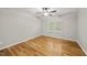 Empty bedroom with hardwood floors, ceiling fan, and natural light streaming through windows at 13017 Townfield Dr, Raleigh, NC 27614