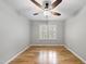 Empty bedroom featuring hardwood floors, ceiling fan, and shuttered windows at 13017 Townfield Dr, Raleigh, NC 27614