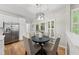 Cozy dining area with hardwood floors, a stylish chandelier, and a view of the screened patio at 13017 Townfield Dr, Raleigh, NC 27614