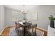 Bright dining room features a modern chandelier and a stylish rug over hardwood floors at 13017 Townfield Dr, Raleigh, NC 27614