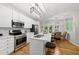 Open kitchen showcasing stainless steel appliances, white cabinetry, and an island with barstool seating at 13017 Townfield Dr, Raleigh, NC 27614