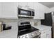 Close-up of kitchen featuring a stainless steel oven, microwave, and backsplash at 13017 Townfield Dr, Raleigh, NC 27614