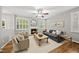 Comfortable living room with a fireplace, ceiling fan, and hardwood floors and many windows at 13017 Townfield Dr, Raleigh, NC 27614