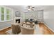 Cozy living room with fireplace, ceiling fan and neutral colors with many windows and wood floors at 13017 Townfield Dr, Raleigh, NC 27614