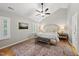 Relaxing main bedroom with vaulted ceiling, ceiling fan, and a decorative rug over wood floors at 13017 Townfield Dr, Raleigh, NC 27614