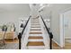 Inviting staircase with hardwood steps, a white banister, and an open view of the home's interior at 13017 Townfield Dr, Raleigh, NC 27614
