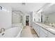 Bathroom featuring a soaking tub, glass shower, granite counters, and double sinks at 1309 Magnolia Gln Cir, Wake Forest, NC 27587