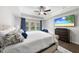 Main bedroom with ensuite, flat screen tv, dark wood floors, and natural light at 1309 Magnolia Gln Cir, Wake Forest, NC 27587