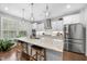 Bright kitchen features stainless appliances, white cabinets, a granite island, and wood floors at 1309 Magnolia Gln Cir, Wake Forest, NC 27587
