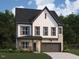 Charming two-story home featuring a mix of siding and stone with an attached two-car garage at 1405 Malcus Ct # 59, Fuquay Varina, NC 27526