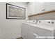 Well-organized laundry room with modern white appliances, built-in cabinets, and stylish decor at 15 Celtic Ln, Lillington, NC 27546