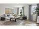 Bright living room features a comfortable sectional sofa, modern decor, large windows, and an elegant rug at 15 Celtic Ln, Lillington, NC 27546