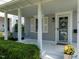 Inviting front porch with a swing, white columns, and a lovely view to the property at 1510 Hanover St, Raleigh, NC 27608