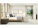 Well-lit bedroom with a bed, bedside table, seating area, and large windows for a bright and airy feel at 1552 Bright Coral Trl, Wendell, NC 27591