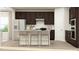 Modern kitchen with dark wood cabinets, stainless steel appliances, a breakfast bar with seating, and light countertops at 1552 Bright Coral Trl, Wendell, NC 27591