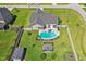 A high aerial view shows the backyard pool, pergola, and fenced yard backing up to an adjacent house at 17 Kaki Ct, Selma, NC 27576