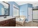 Relaxing bathroom with a soaking tub, blue walls, and elegant fixtures at 17 Kaki Ct, Selma, NC 27576