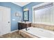 Bright bathroom featuring a large soaking tub, tiled floors, and a vanity at 17 Kaki Ct, Selma, NC 27576