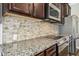 Gourmet kitchen with stainless appliances, granite counters, and stylish backsplash at 17 Kaki Ct, Selma, NC 27576