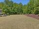 Expansive backyard with well-maintained lawn, mature trees, and landscaping, perfect for outdoor activities at 1701 Bodwin Ln, Apex, NC 27502