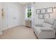 Cozy bedroom area featuring a comfortable armchair, decorative cabinet, and bright, natural light at 1701 Bodwin Ln, Apex, NC 27502