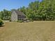 Green two-story home with a large backyard, mature trees, outdoor seating, and well-maintained lawn at 1701 Bodwin Ln, Apex, NC 27502