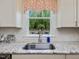 Kitchen sink with granite countertops and a window overlooking the backyard at 1701 Bodwin Ln, Apex, NC 27502