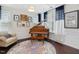 View of a formal living room with grand piano, window seating and decorative rug at 1701 Bodwin Ln, Apex, NC 27502