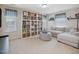 Spacious living room with a large shelving unit, comfortable seating, and natural light at 1701 Bodwin Ln, Apex, NC 27502