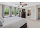 Main bedroom with a ceiling fan and three large windows, complemented by ensuite access at 1701 Bodwin Ln, Apex, NC 27502