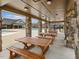 Covered poolside seating area with stone pillars and wooden picnic tables at 1701 Bodwin Ln, Apex, NC 27502