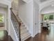Staircase leading to a dining room with abundant natural light and dark hardwood floors at 1701 Bodwin Ln, Apex, NC 27502