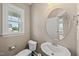 Bathroom with a window, toilet, sink and a mirror on the wall at 178 Ashpole Trl, Clayton, NC 27520