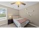 Cozy bedroom featuring neutral walls, ceiling fan, and a comfortable bed with throw pillows, and a bedside table at 178 Ashpole Trl, Clayton, NC 27520