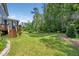 Picturesque backyard with a lawn, trees, and a play area for outdoor enjoyment at 1813 Lost Creek Ct, Apex, NC 27539
