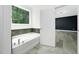 This is a bathroom with a tub, shower and window that looks into a green space at 1813 Lost Creek Ct, Apex, NC 27539