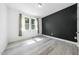 Bedroom with light floors, bright white walls, a black accent wall, and large windows at 1813 Lost Creek Ct, Apex, NC 27539