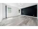 Stylish bedroom featuring grey wood floors, a black accent wall and modern circular lighting at 1813 Lost Creek Ct, Apex, NC 27539
